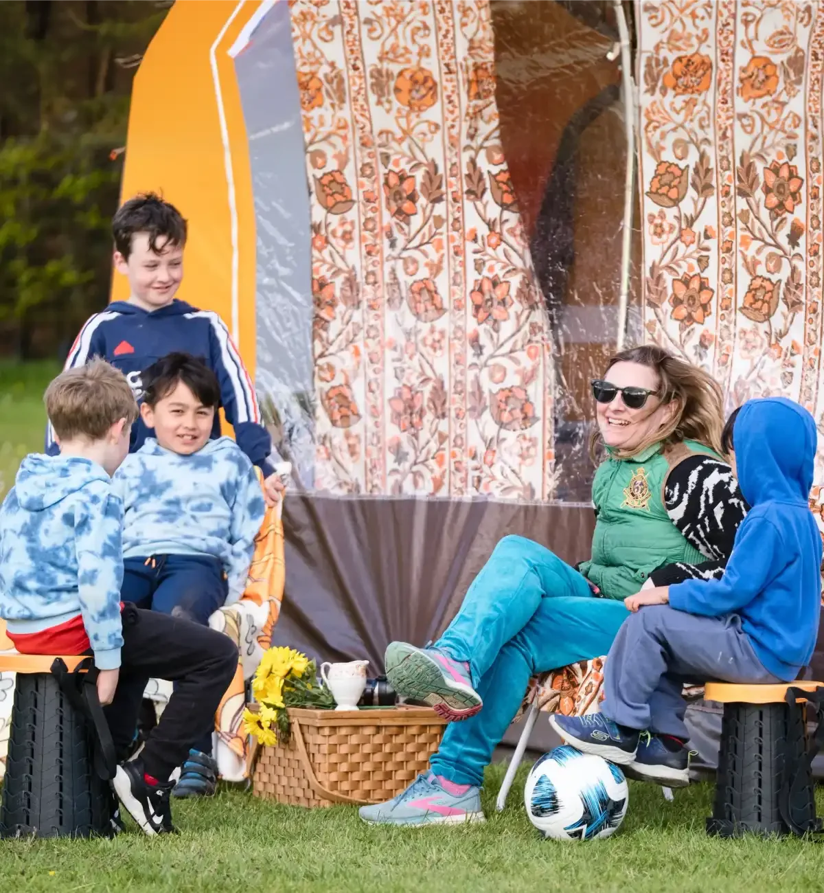 Family sitting by tents and camping pitch at Willowbrook